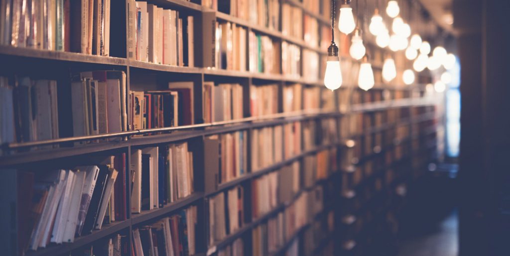 Ein Gang in einer Bibliothek ausgeleuchtet mit Lampen