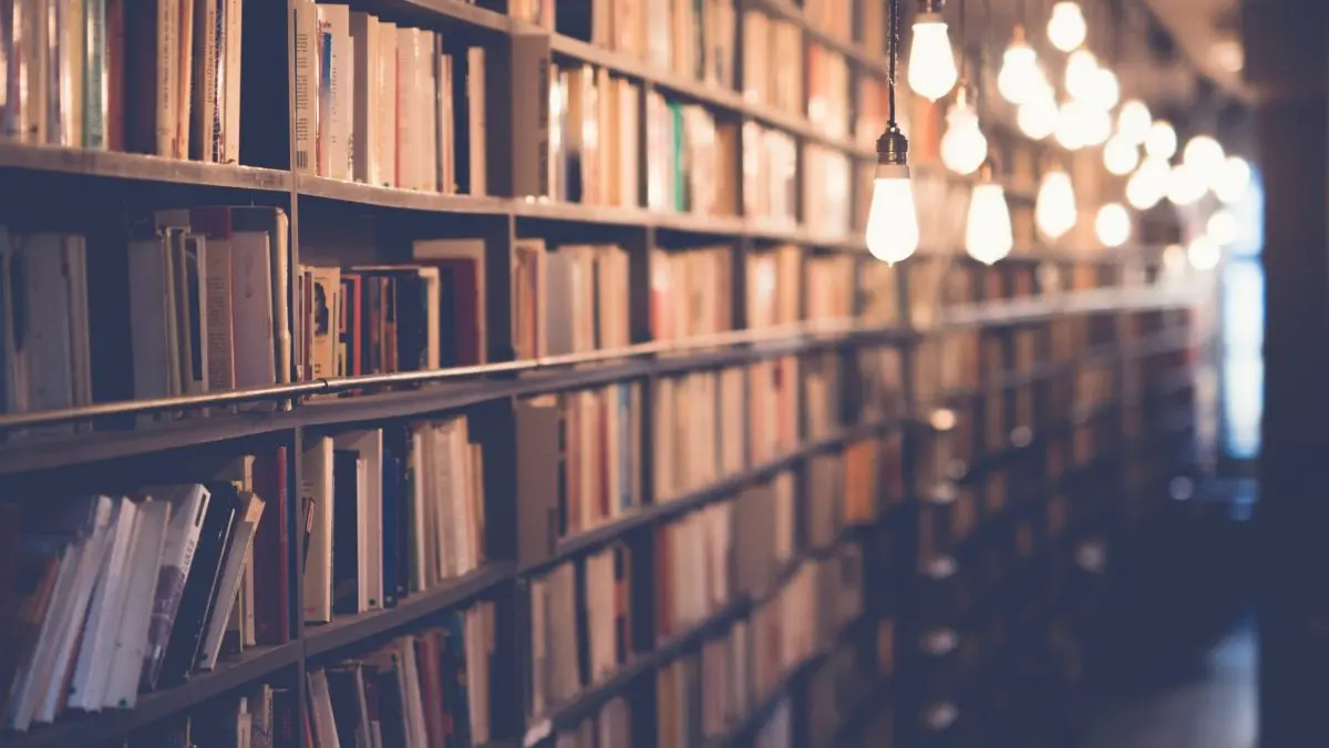 Ein Gang in einer Bibliothek ausgeleuchtet mit Lampen