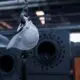 Weißer Helm hängt an Haken in Fabrikhalle